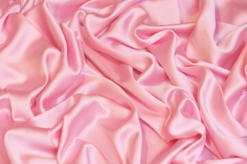 Close-up of soft, flowing baby pink Charmeuse satin texture. Ideal luxurious background for high-end fashion, beauty, or celebration themes.