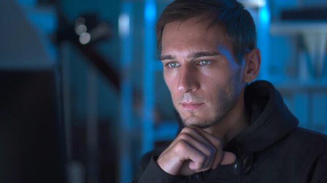 Programmer working late at night on code in a modern tech workspace.