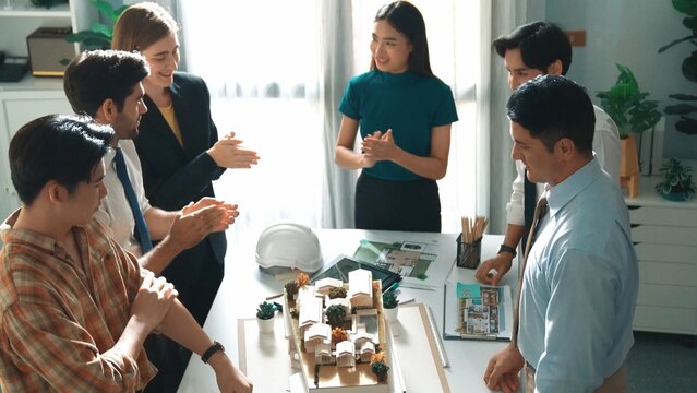 Top view of manager shake hands and making a deal at meeting table with architectural model, blueprint and safety helmet. Aerial view of project manager shaking hands or making deal. Alimentation.