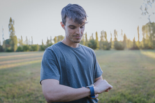 Athletic young man using smartwatch to track performance outdoors