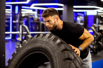 Sculpting strength at the gym with tire flipping and focused determination