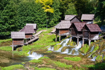 Small water mills on poles at Pliva lake, tourist destination near Jajce