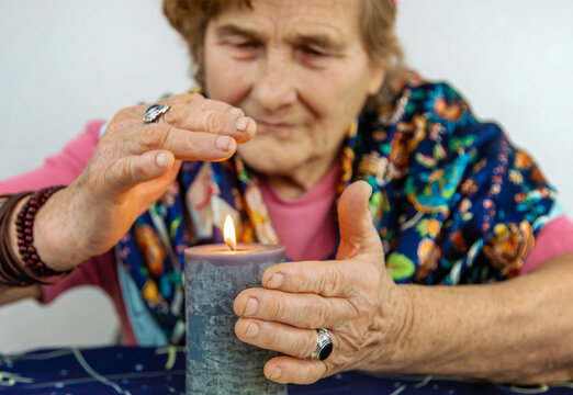 Woman fortune teller fortune telling on a candle. Selective focus.