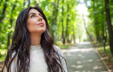 Relaxed woman breathing fresh air in a green summer park 