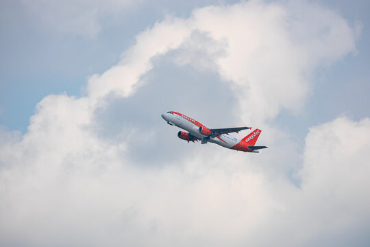 A red and white EasyJet taking off in blue cloudy sky: Munich, Germany - September 15, 2018
