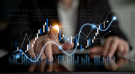 A professional setting showcasing financial growth through digital graphs and charts. The image captures hands analyzing data on a screen, illustrating trends and performance metrics. Scalp