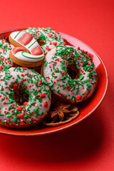 Christmas donuts or doughnuts, holiday winter sweets with sprinkles. Christmas donuts