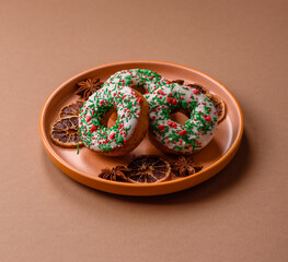 Christmas donuts or doughnuts, holiday winter sweets with sprinkles. Christmas donuts