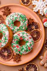Christmas donuts or doughnuts, holiday winter sweets with sprinkles. Christmas donuts