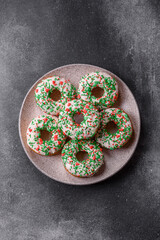 Christmas donuts or doughnuts, holiday winter sweets with sprinkles. Christmas donuts