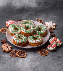 Christmas donuts or doughnuts, holiday winter sweets with sprinkles. Christmas donuts