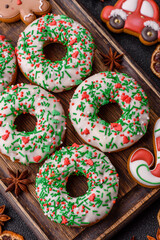 Christmas donuts or doughnuts, holiday winter sweets with sprinkles. Christmas donuts