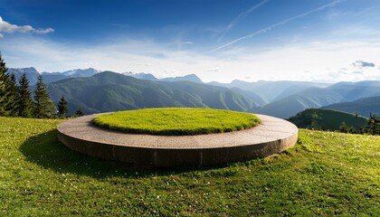 circular grass podium on a hilltop with a panoramic view of mountains