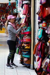 Obraz premium Young Woman Shopping for Handicrafts in Cusco