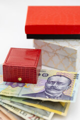 A stack of colorful Romanian Leu (RON) banknotes (100, 20, 10 Lei) piled on top of elegant gift boxes, symbolizing wealth, expenses, and luxury shopping