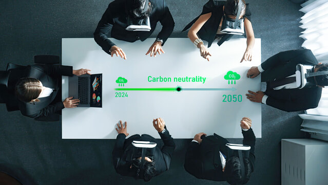 Professionals engage in a corporate strategy meeting focusing on carbon neutrality goals for 2024 to 2050, utilizing virtual reality for innovative planning. Trope - Powered by Adobe