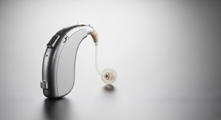 Single gray and metallic hearing aid for hearing loss treatment. Modern medical technology for auditory health and sound improvement.