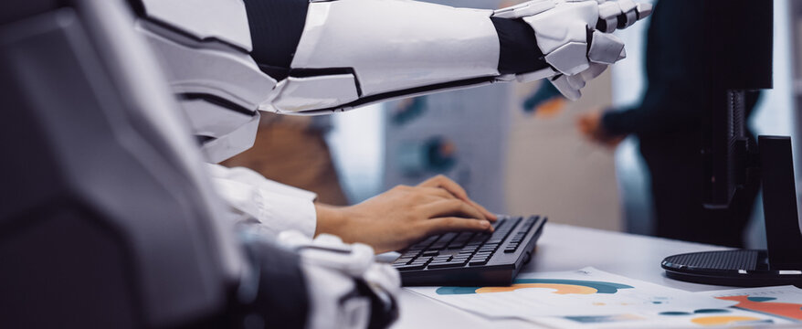 A robotic arm is seen interacting with a keyboard in a contemporary office, highlighting the synergy between advanced technology and human work.Noogenesis - Powered by Adobe