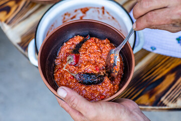 A man cooks traditional lamb soup in a cauldron over an outdoor fire in the Gagauzia autonomous region of Moldova. 