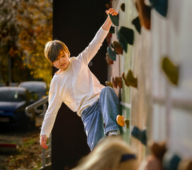 Teenager on a Climbing Wall. Outdoor Bouldering and Active Autumn Leisure.