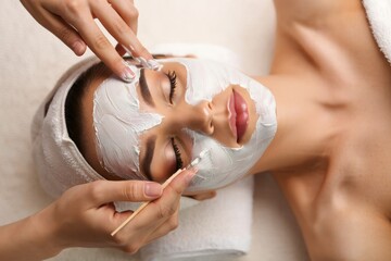 Woman receiving facial mask treatment at spa for skincare and relaxation