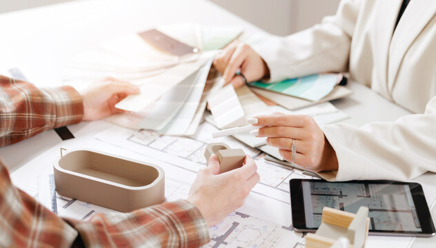 Collaborative workspace presentation: designers planning with color palettes and architectural models - Powered by Adobe