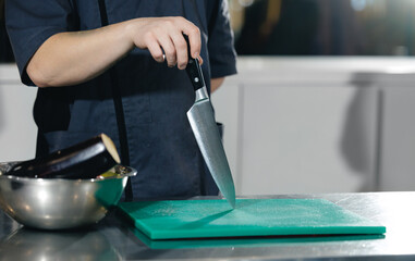 Close-up of chef slicing vegetables in professional kitchen setting