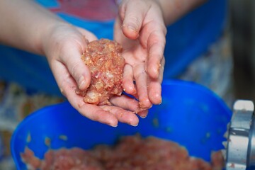 Chef's hands shaping a meat patty from fresh mince in a professional kitchen