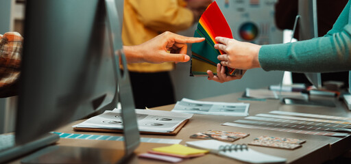 Engaging scene in a design studio showing hands selecting a vibrant color palette. This collaborative moment captures creativity and teamwork in the creative process. SACTR