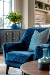 Obraz premium Stylish blue velvet chair with decorative pillow next to a wooden table and modern decorative vase in a bright, cozy living room