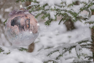 Christmas bauble hanging on a Christmas tree covered in snow. Christmas bauble with bison - a symbol of Podlasie
