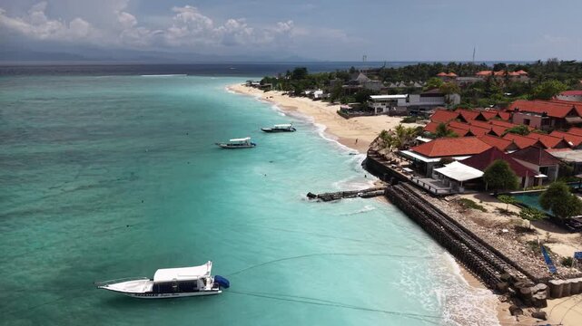 Beautiful sea coastline with waves of Bali, Nusa Lembongan Suka beach Island drone aerial shot in Indonesia surrounded by beautiful jungle and tropical blue sea water and cliffs