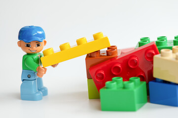 Naklejka premium Lego minifigure with colorful building blocks on white background. Lego is extremely popular worldwide with children and collectors.