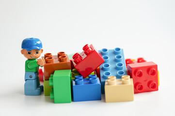 Naklejka premium Lego minifigure with building bricks isolated on a white background.