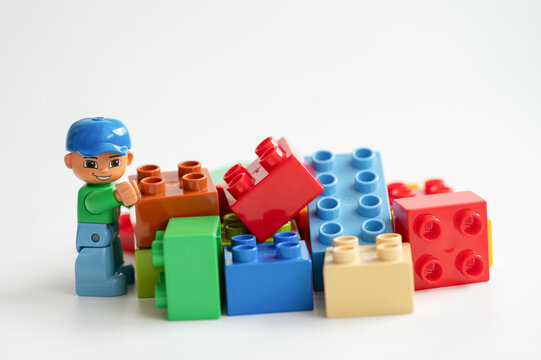 Lego minifigure with building bricks isolated on a white background.