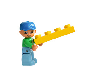 Naklejka premium A Lego Duplo man holding a Lego brick on a white background.