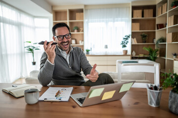 Happy man laughing while speaking on smartphone