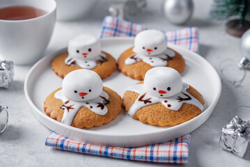 Obraz premium Gingerbread cookie with melting snowman topping on a white background