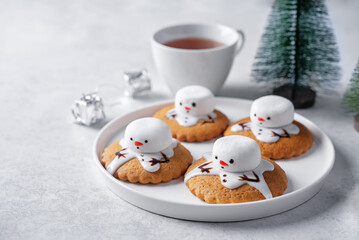 Gingerbread cookie with melting snowman topping on a white background