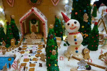 christmas gingerbread house decoration with snowman candy and white icing like snow