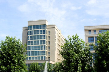 Background of the facade of a house with large windows and trees in summer.	