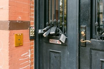 Locks and security devices on a door in a city, showcasing an unusual method of securing access