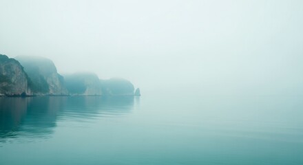 Misty sea with rocky island landscape. Tranquil blue green ocean water scene. Nature background for serenity and calm concept.