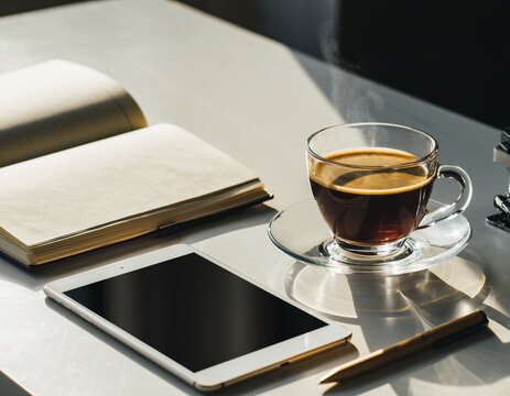 Morning coffee on workspace with notebook and tablet