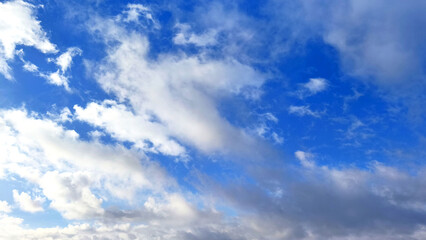 Obraz premium Beautiful blue sky with fluffy white clouds on a bright sunny day