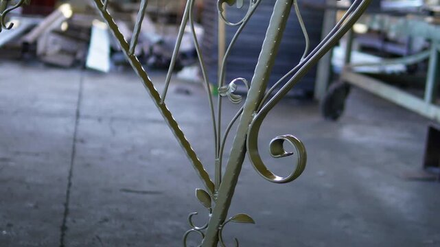 Decorative forged metal railings. The painted railings hung in the workshop. Elegant iron scrolls with detailed work.