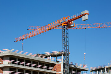 cranes on construction site with blue sky on a background 