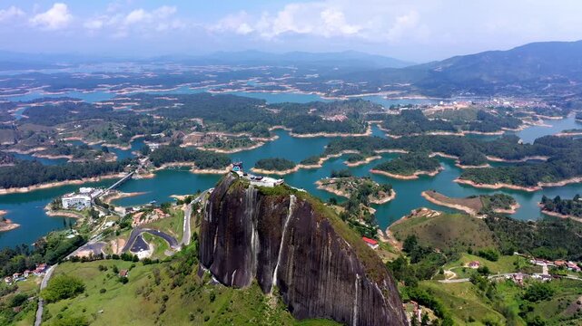 Aerial drone view of El Penon rock above Guatape reservoir islands near Guatape Antioquia Colombia sunny day