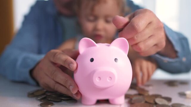 Child is playing with piggy bank full of coins. kid finance father concept. family with baby in a bank with piggy bank. a lifestyle family with a baby and coins in a bank.