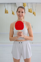 Smiling Woman Holding a Red Table Tennis Paddle